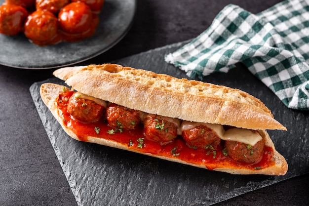 Meatball sub sandwich on black slate table