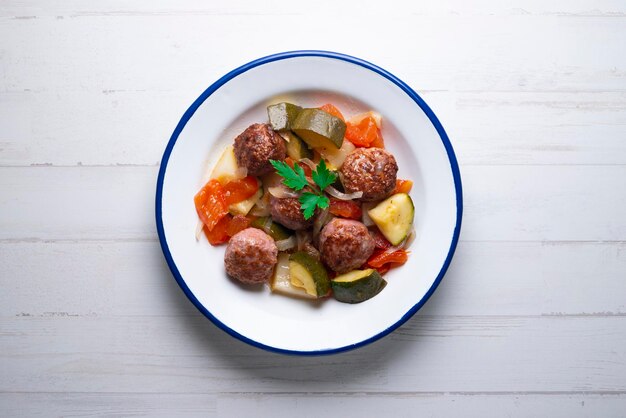 Meatballs cooked with assorted baked vegetables.