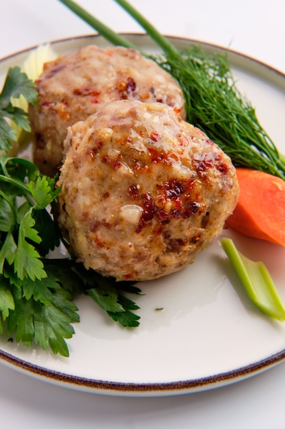 Foto le polpette sono servite con carote fresche, cipollotti e parsey