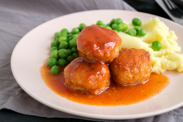 Meatballs in sweet and sour tomato sauce with mashed potatoes.