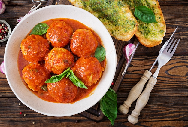 Meatballs in tomato sauce and toast with basil pesto.