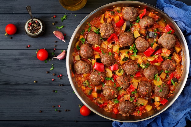 Meatballs in tomato sauce and vegetables in stew-pan