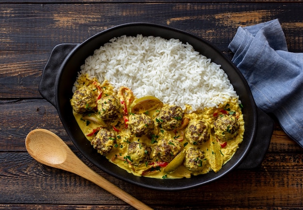 Photo meatballs with rice, curry sauce, lime and red pepper. healthy eating.