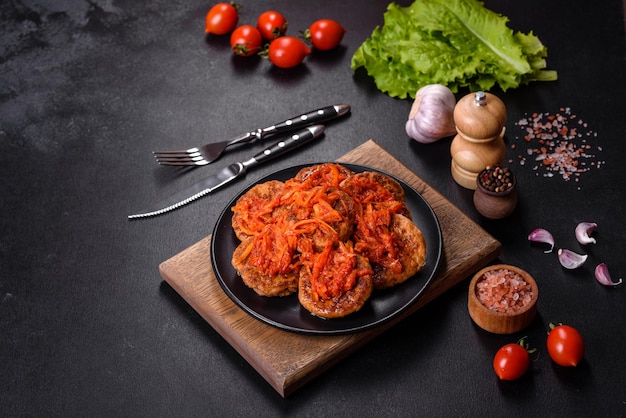 Meatballs with tomato sauce and herbs on the black plate