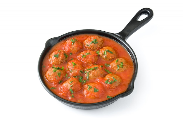 Meatballs with tomato sauce in iron frying pan isolated on white