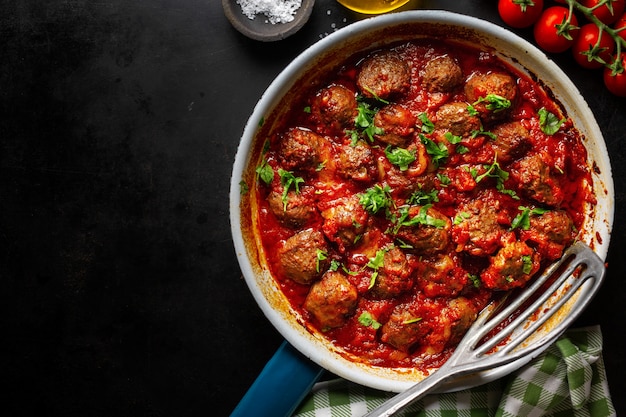 Photo meatballs with tomato sauce served in pan