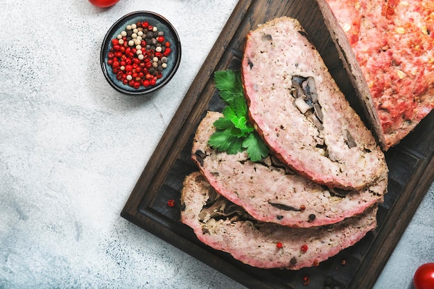 Meatloaf with mashrooms american food with baked pork beef minced meat on gray table Top view copy space