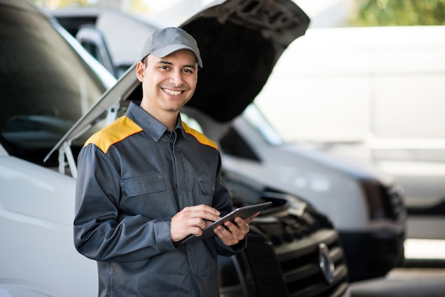 Mechainc using a tablet in front of a van