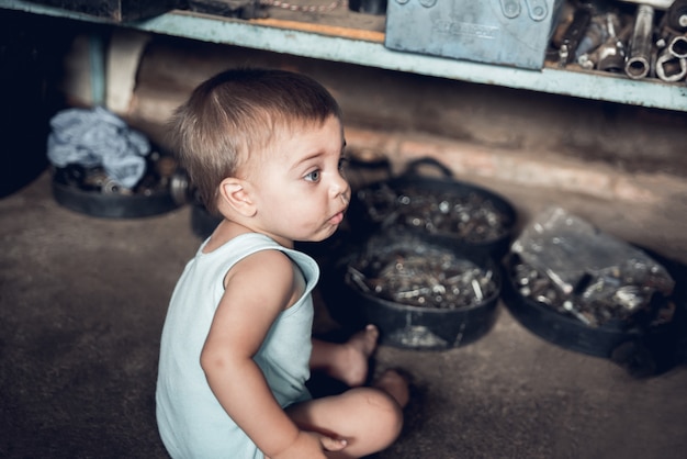 Mechanic Baby Boy - Sitting on the floor of a shop