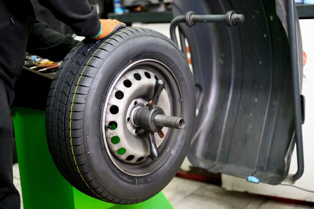 Mechanic balancing a car wheel.