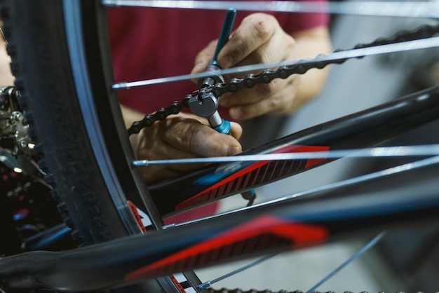 自転車のチェーンを固定する自転車修理工場のメカニック