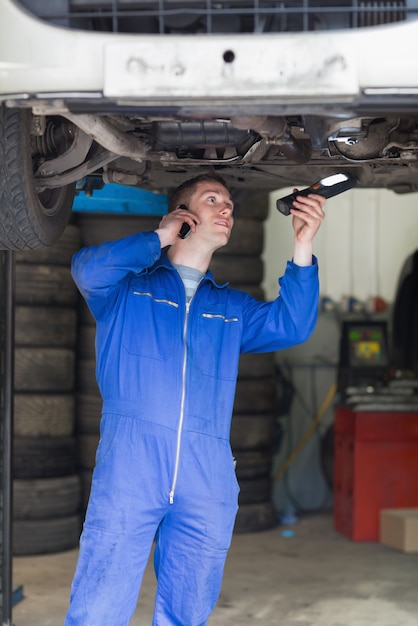 Mechanic on call as he examines car