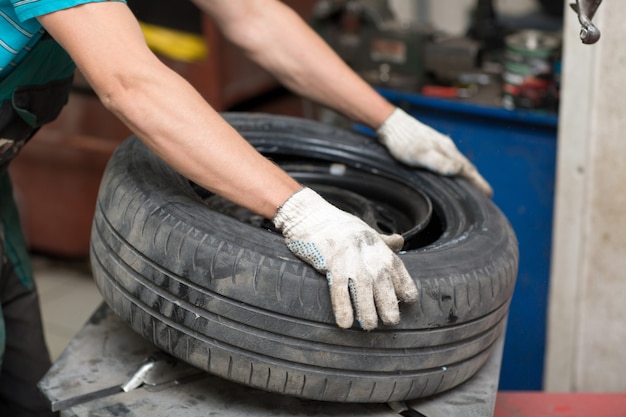 Mechanic changing car tire fitting. Wheel tyre repairing.