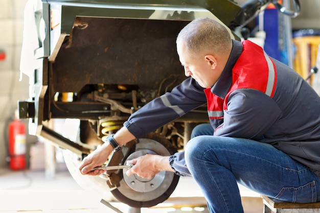 Photo mechanic changing a wheel of car