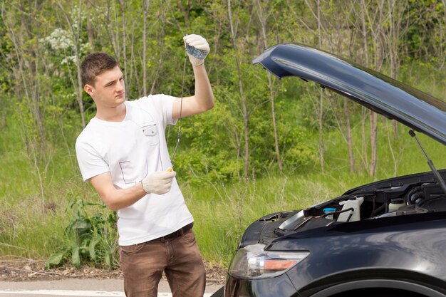 Mechanic checking the level of the oil on a car