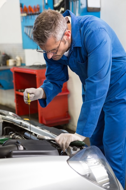 Mechanic checking the oil of car