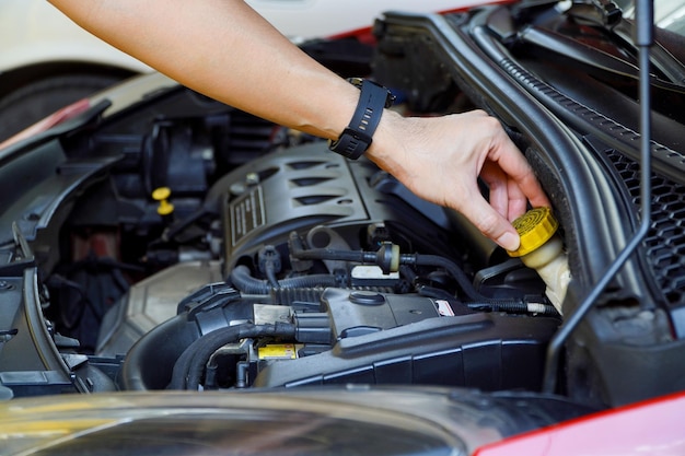 Mechanic checks the brake fluid in the engine compartment and the vehicle's basic service concept