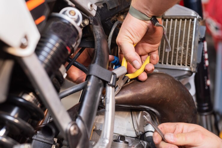 mechanic close up repairing motorbike in repair garage.