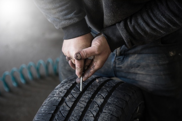 Mechanic closes a hole in a tire in a workshop