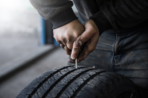 Mechanic closes a hole in a tire in a workshop