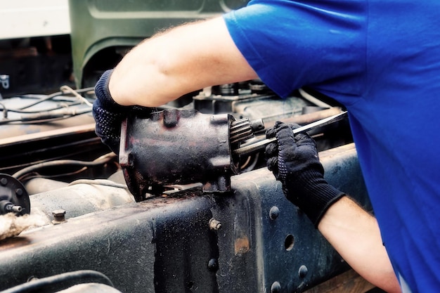 Mechanic disassembles and repairs truck Closeup rear view Professional service of cargo workers