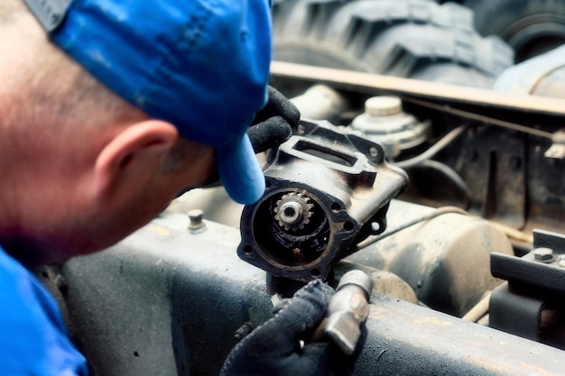 Mechanic disassembles and repairs truck Closeup rear view Professional service of cargo workers