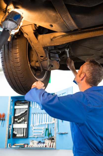 Photo mechanic examining under the car