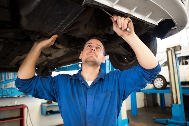 Mechanic examining under the car