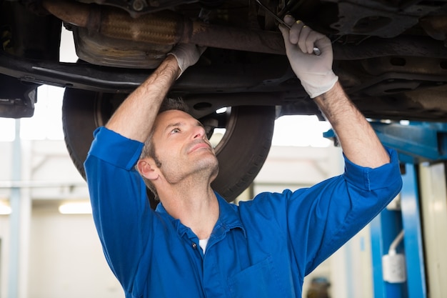 Mechanic examining under the car