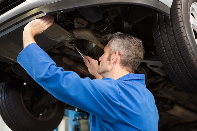 Mechanic examining under the car