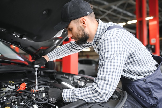 Mechanic examining under hood of car at the repair garage