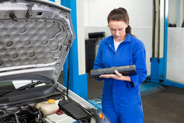 Mechanic examining under hood of car