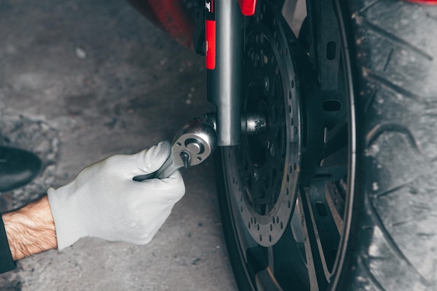 Mechanic fixing a motorcycle in the garage