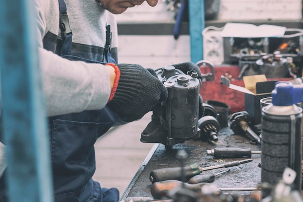 The mechanic fixing one of working car parts