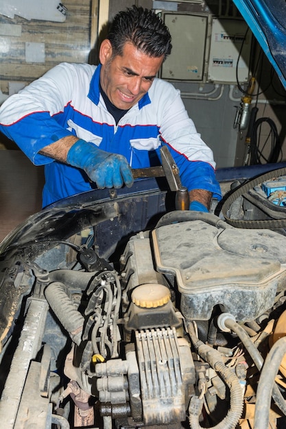 修理所で車の機械的なハンマーエンジン