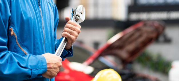 mechanic hand holding wrench equipment in auto repair shop