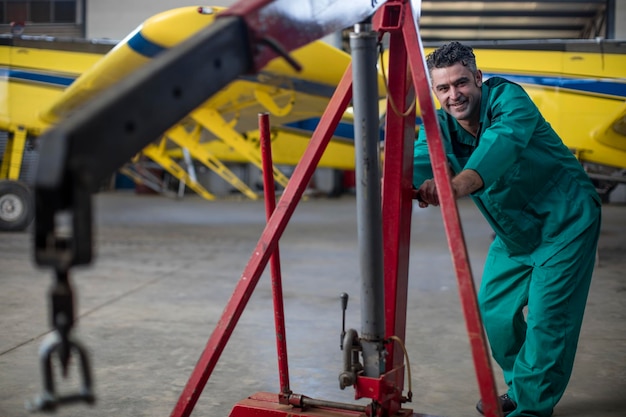 Foto meccanico in hangar che ripara velivoli leggeri