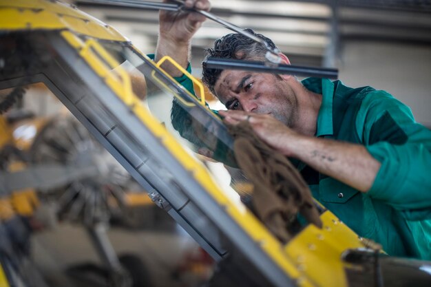 Photo mechanic in hangar repairing light aircraft