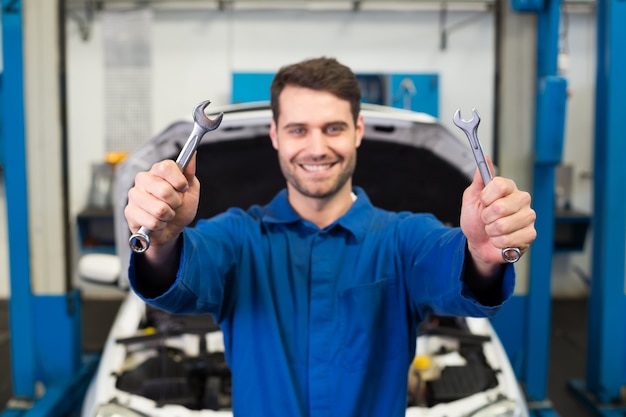 Mechanic holding pair of wrenches