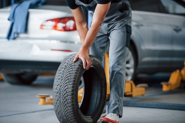 Mechanic holds a tire at the repair garage