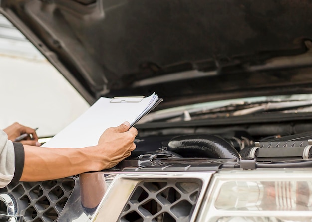 The mechanic inspects the engine of the car according to the check schedule