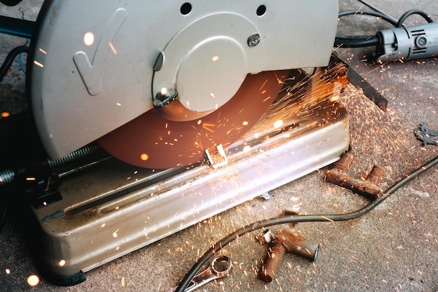 A mechanic is using a cut off saw to cut steel pipes in a
factory