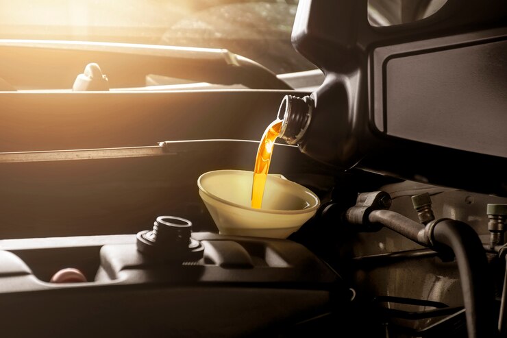 Photo mechanic man pouring engine oil to car engine