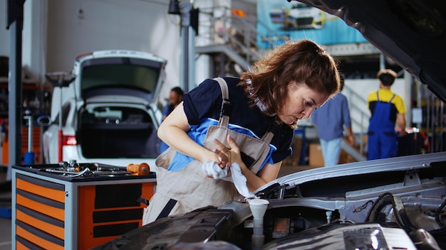 Mechanic in repair shop using torque wrench to tighten screws after opening car to check its parameters during maintenance Specialist using professional tool in garage to recondition busted vehicle