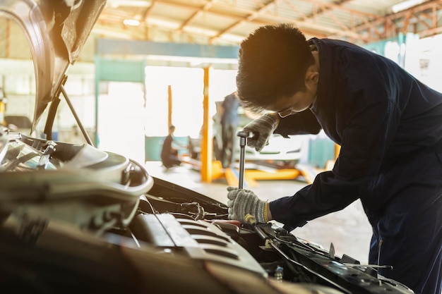 Foto meccanico che ripara l'auto in un negozio di riparazione automobilistica