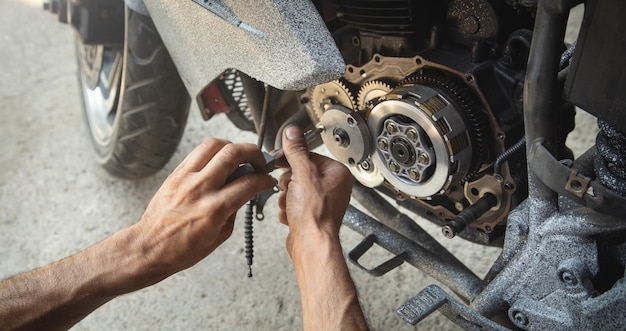 Mechanic repairing engine of motorcycle Concept of motorcycle maintenance