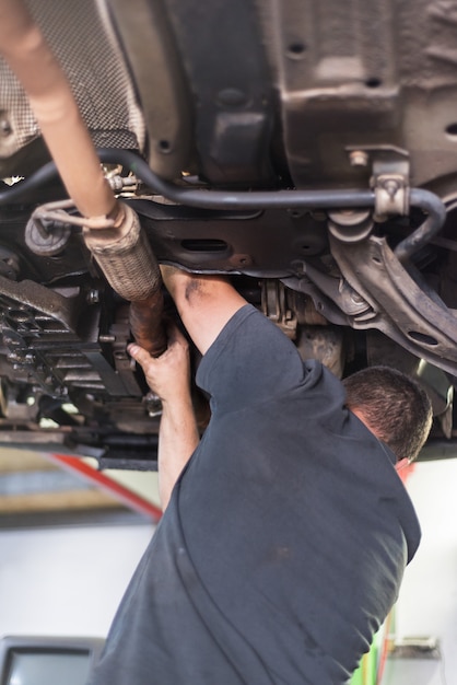 Mechanic repairing exhaust system