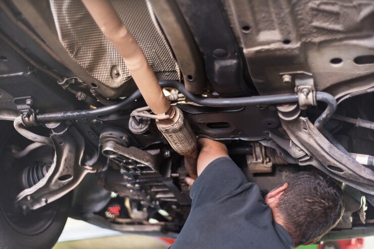 Mechanic repairing exhaust system