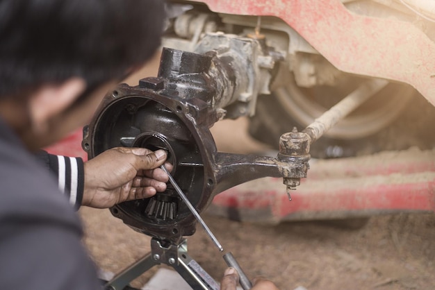 Mechanic repairing tractor axle close to axle