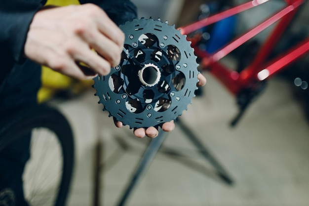 Mechanic repairman assembling custom bicycle in workshop